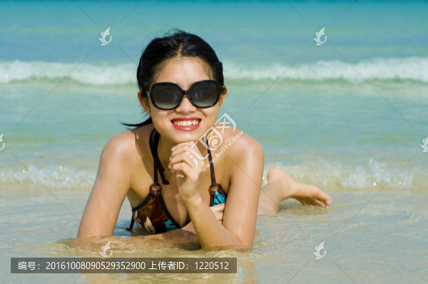 美麗的海灘與心反映在她的太陽鏡