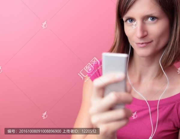 年輕漂亮的女人在她的便攜式MP3播放器聽音樂