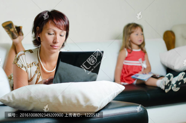 一個(gè)帶著筆記本和女兒的年輕母親