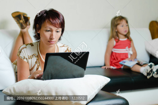 一個(gè)帶著筆記本和女兒的年輕母親