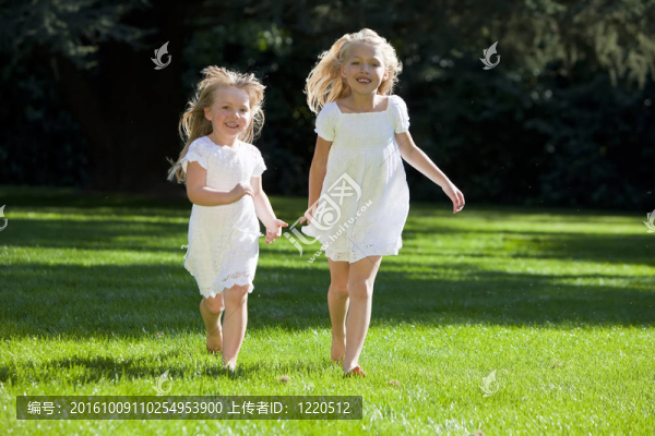 兩個(gè)年輕漂亮的女孩穿過(guò)陽(yáng)光燦爛的綠色公園