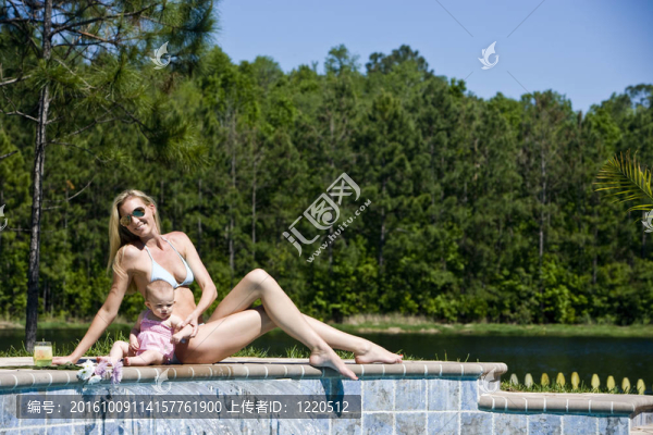 母親帶著六個月大的嬰兒挨著游泳池