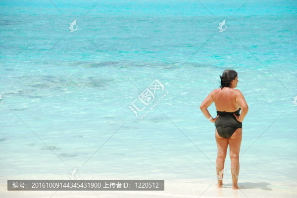 高級女子望著藍色充滿活力的海洋