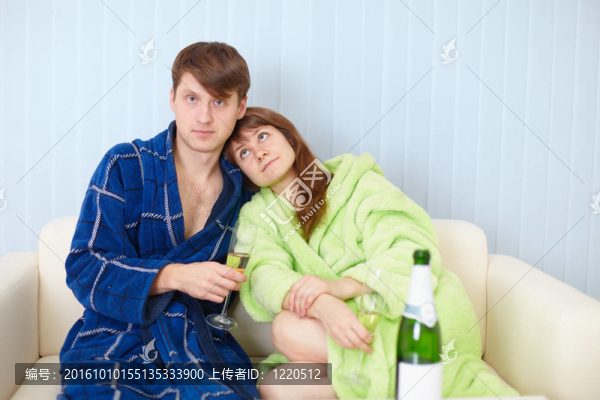 年輕的一對在家里沙發(fā)上起泡酒