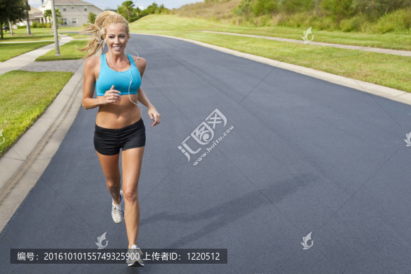 美麗的金發(fā)女子跑步和聽MP3播放器