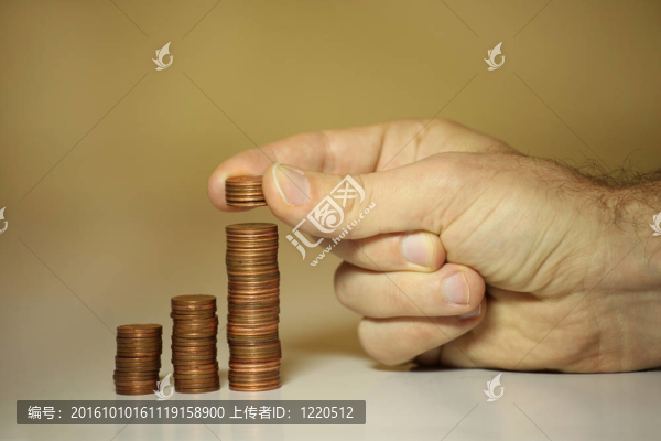 男性的雙手堆疊美分和美分，以節(jié)省資金