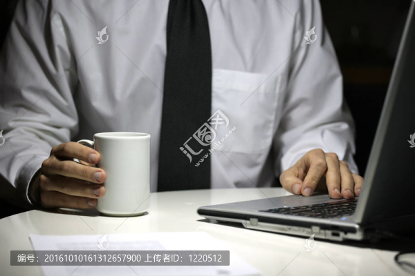 商務(wù)人士與咖啡杯工作在筆記本電腦