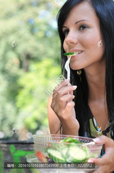 在戶外吃沙拉的年輕婦女