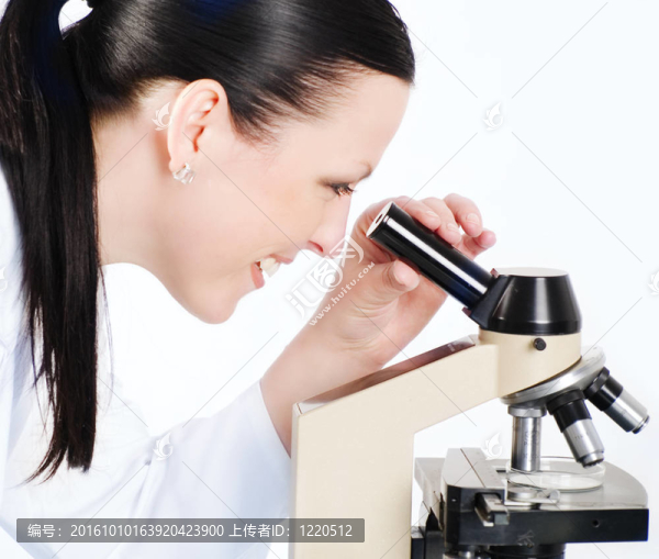 微笑的女醫(yī)學的女人在一個顯微鏡研究