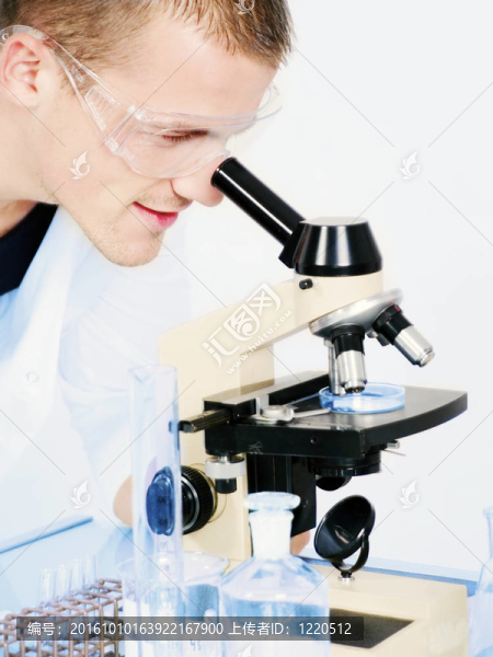 微笑的人在顯微鏡下研究