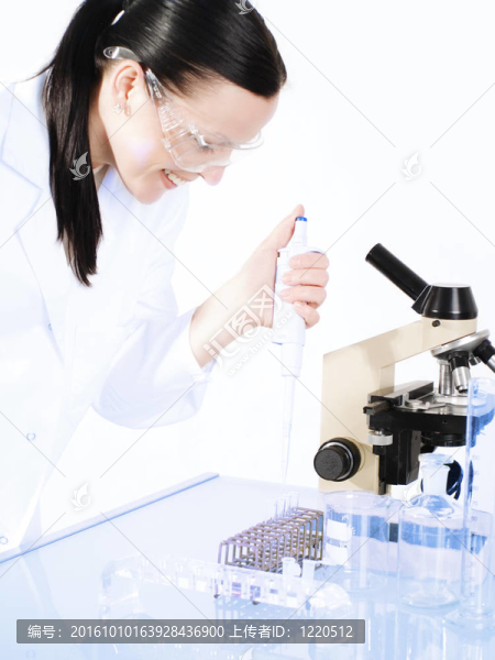 微笑的女醫(yī)學(xué)的女人在一個顯微鏡研究