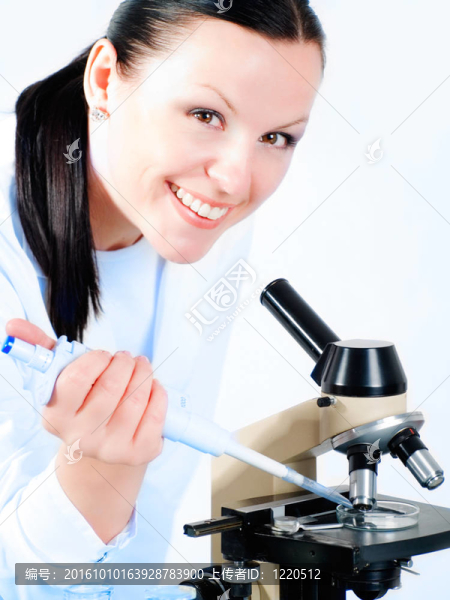 微笑的女醫(yī)學(xué)的女人在一個顯微鏡研究