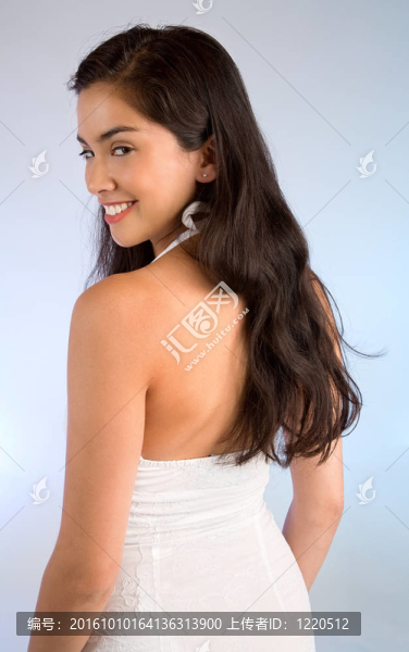 美麗的女士穿著白色的連衣裙向后看