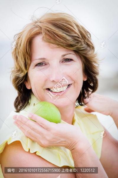 美麗的成熟女人拿著一個蘋果