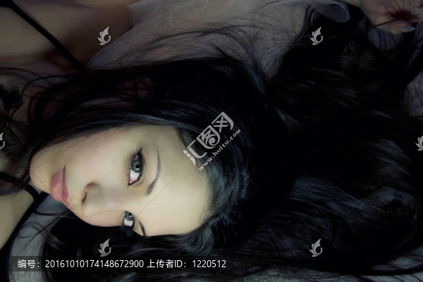 美麗的女人躺在白色的絲綢