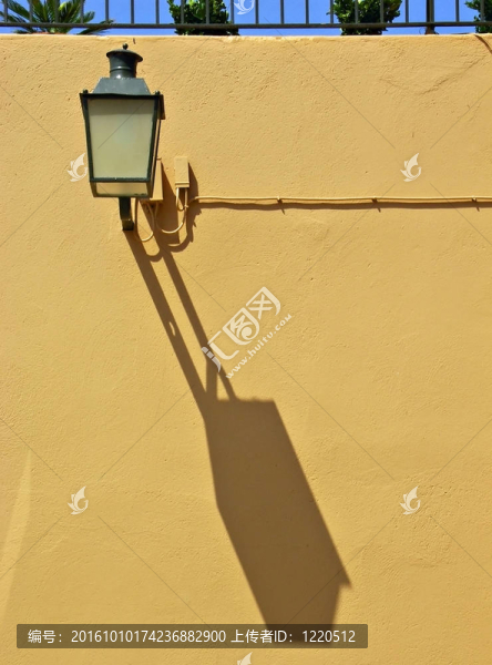 在Calella,de帕拉弗魯赫爾墻上的Streetlamp；加泰羅尼亞；西班牙具有強(qiáng)烈的陰影。