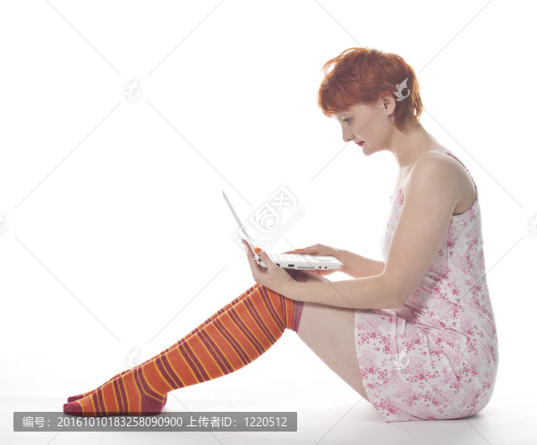紅色女孩在條紋襪子與筆記本電腦白色背景