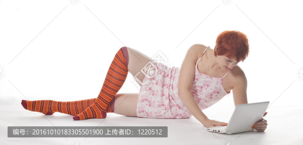 紅色女孩在條紋襪子與筆記本電腦白色背景