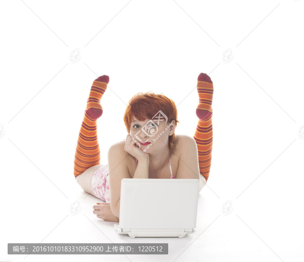 紅色女孩在條紋襪子與筆記本電腦白色背景