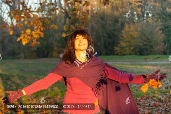 站在落葉下的年輕女子