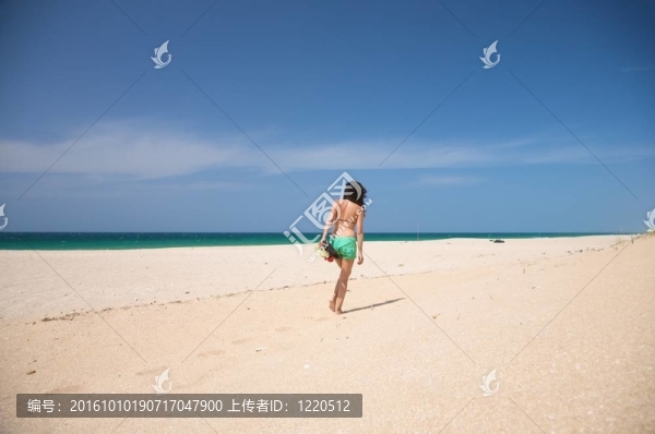 綠色短褲女性走在沙灘上