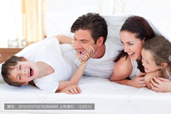 快樂的家庭躺在床上玩的樂趣