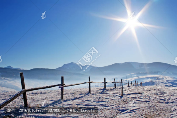 在積雪覆蓋的山脈的木柵欄
