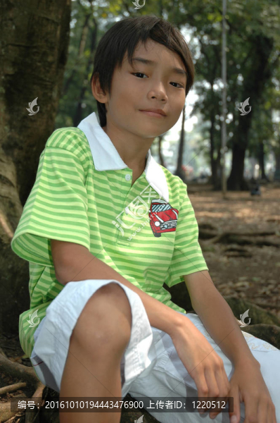 小男孩坐在樹旁