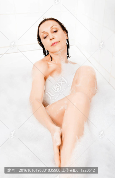 迷人的女人在浴缸里享受。