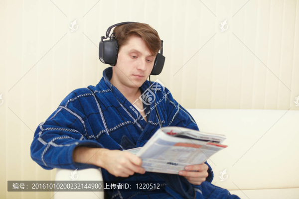 坐在沙發(fā)上的大耳朵的人看雜志