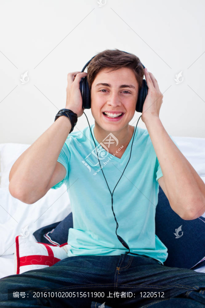 一個十幾歲的男孩在臥室里聽音樂