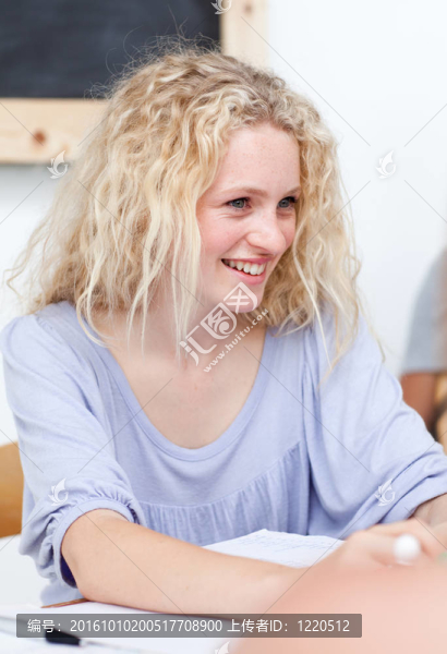 微笑的金發(fā)少年在圖書館做作業(yè)