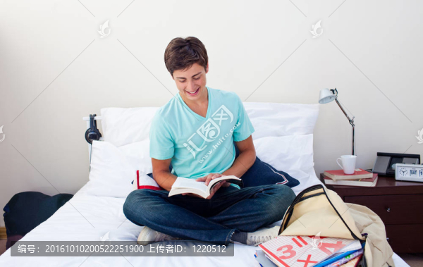 微笑的少年在他的臥室里看書(shū)