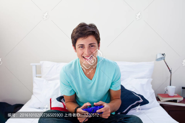快樂的少年在他的臥室里玩電子游戲
