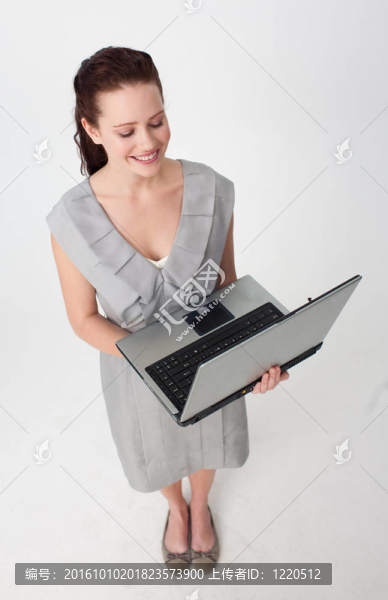 使用筆記本電腦的一個漂亮的女商人高角