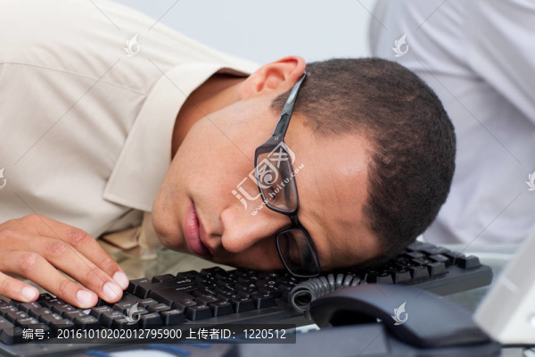 年輕的商人睡在鍵盤上