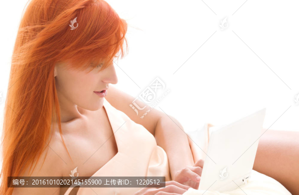 快樂的紅發(fā)女人用筆記本電腦