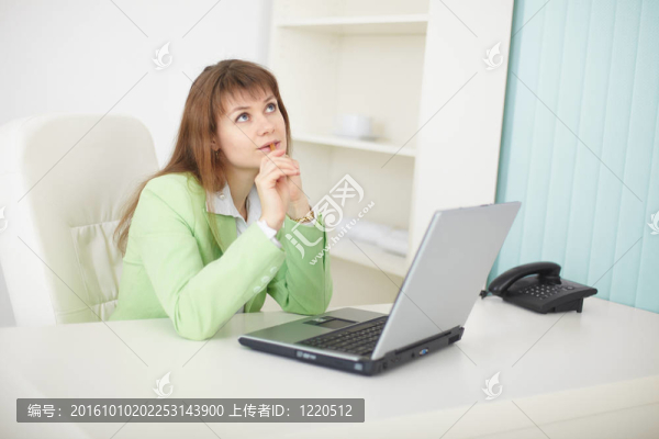 夢幻般的女人坐在辦公桌與筆記本電腦