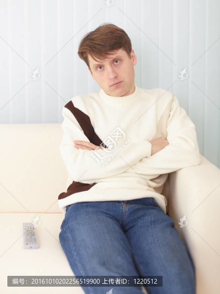 嚴肅的家伙坐在沙發(fā)上遙控