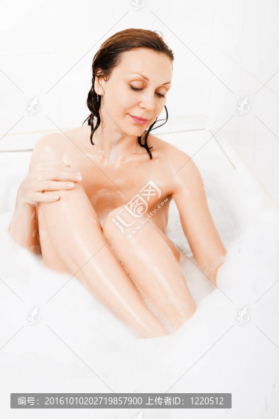 迷人的女人在浴缸里享受。