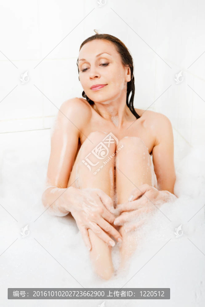 迷人的女人在浴缸里享受。