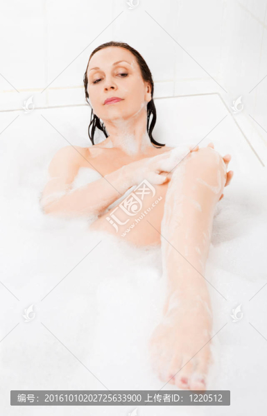 迷人的女人在浴缸里享受。