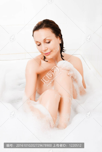 迷人的女人在浴缸里享受。