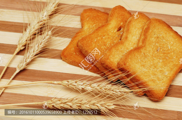 四塊面包片和小麥耳朵在木板上