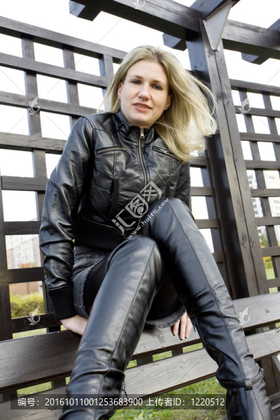 女人穿著時髦的衣服坐在長椅上