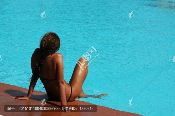 美麗的女孩在游泳池附近。