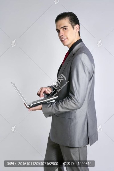 商人在灰色西裝控股筆記本電腦