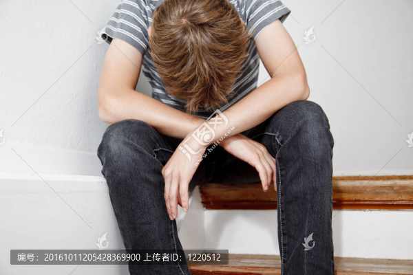 坐在樓梯上的男孩哭了