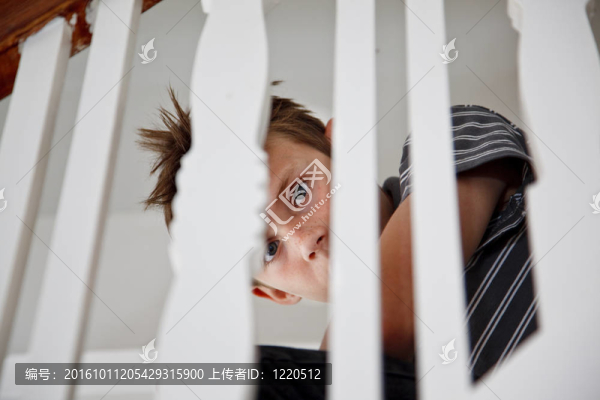 男孩驚恐地通過樓梯扶手