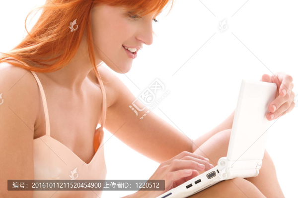 快樂的紅發(fā)女人用筆記本電腦